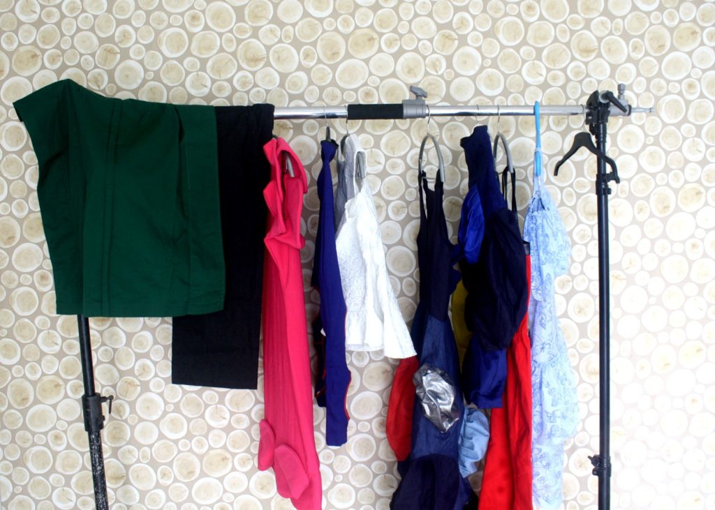A rack of clothes behind the scene of cassie daves mania magazine shoot.