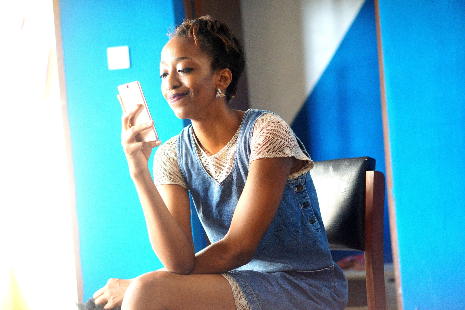 updated blogging process , Nigerian fashion and lifestyle blogger cassie daves looking into a phone screen