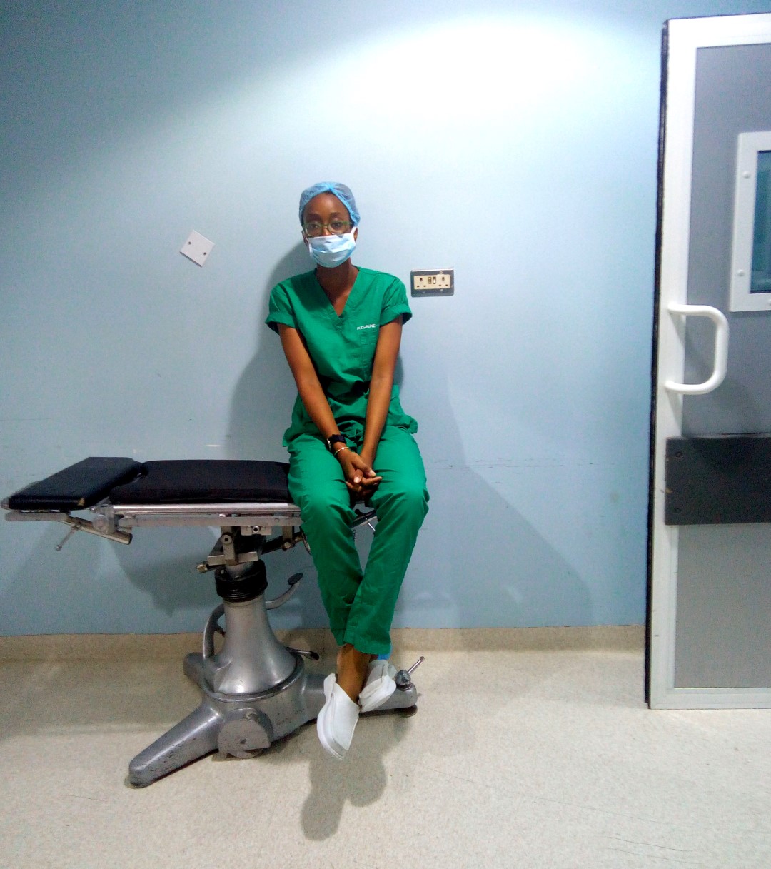 housemanship in nigeria, Nigerian blogger and medical doctor cassie daves in scrubs sitting in the modular theatre