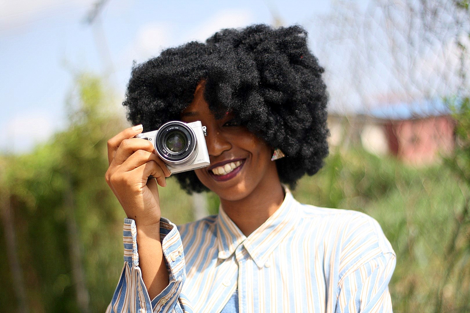 Nigerian lifestyle blogger cassie daves holding the Sony a6000 camera