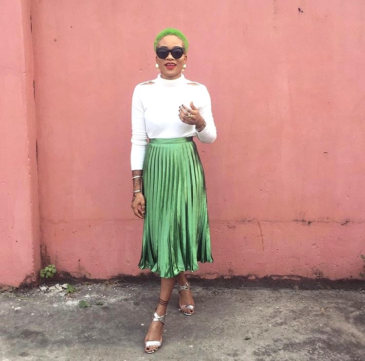 Nigerian fashionista jennifer oseh, theladyvhodka in a green mettalic pleated skirt and white turtle neck top