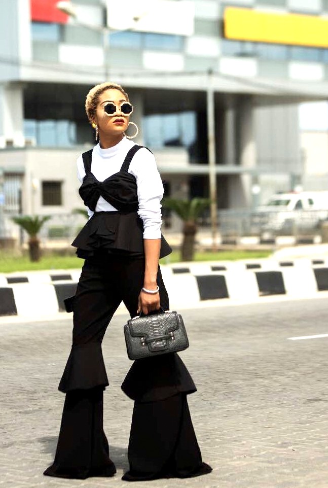 Nigerian style influencer jennifer oseh, theladyvhodka in a black ruffled pants layered with a white turtle neck top