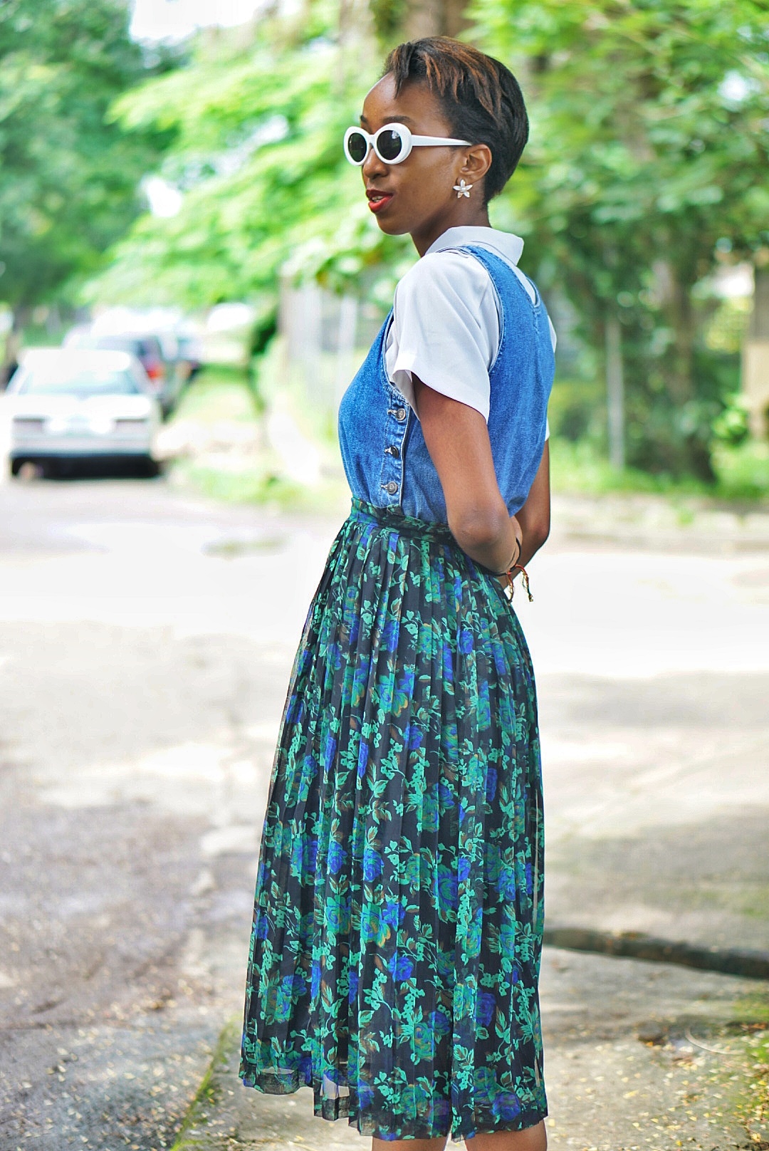 Nigerian fashion blogger Cassie Daves in prints pleated midi skirt and a denim dress layered on a white shirt