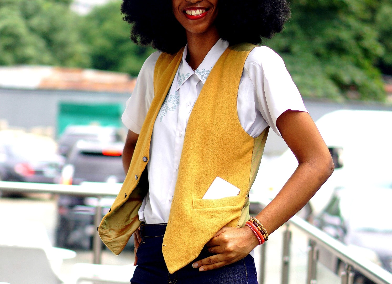 Nigerian Fashion blogger Cassie Daves wearing a mustard waistcoat and white shirt. 