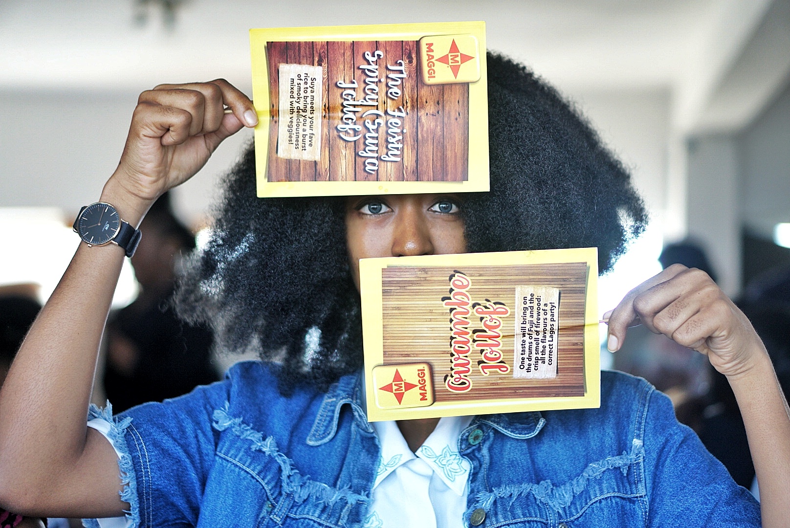 Nigerian fashion blogger Cassie Daves holding up a maggi recipe handfan at the jollof weekend workshop in lagos