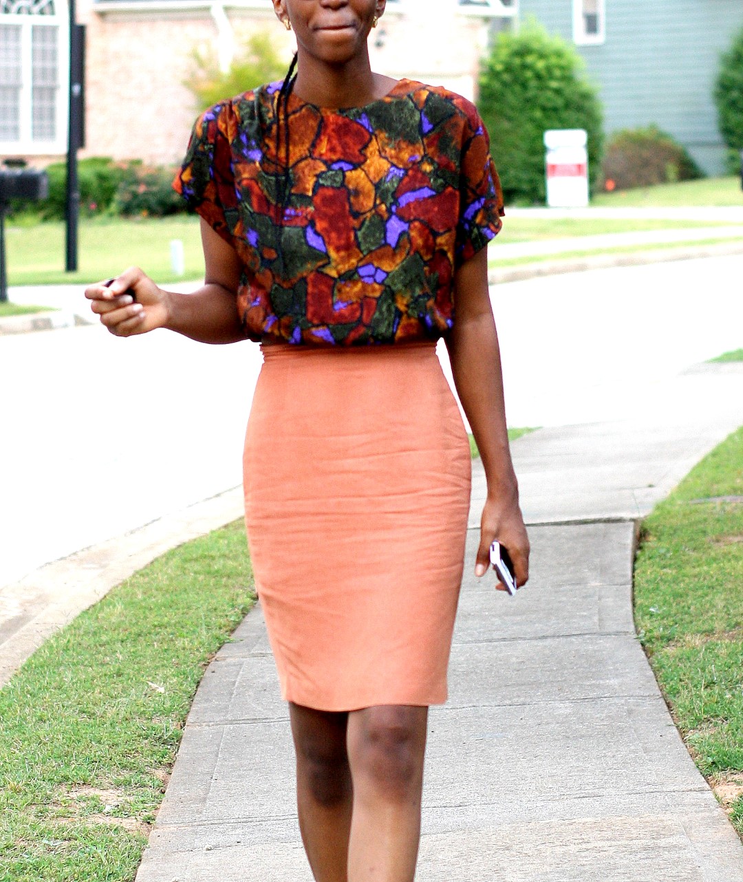 Going back to the basics - Nigerian fashion blogger Cassie Daves in a profile shot wearing a bright coloured prints top, orange skirt in atlanta