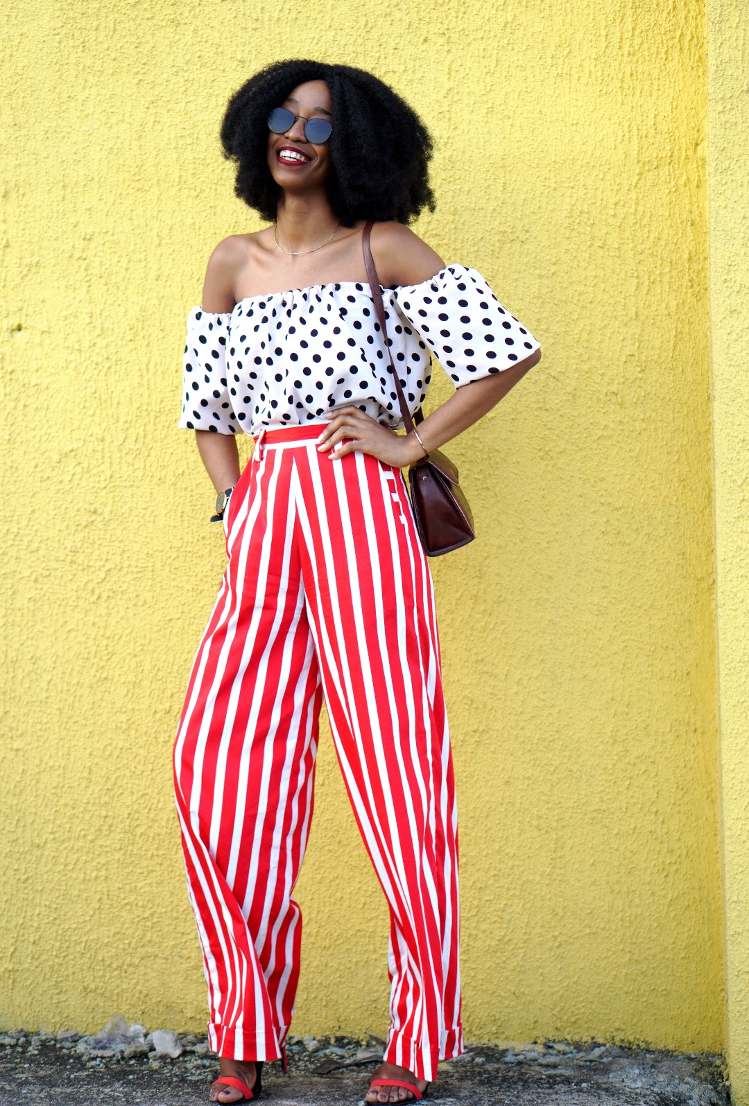 Mixed prints fashion trend : Nigerian fashion blogger Cassie Daves In a polka dot off shoulder top and striped pants and sunglasses