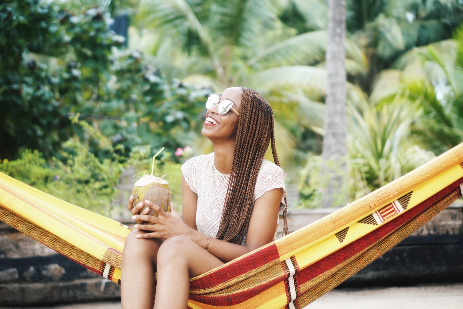 Nigerian blogger Cassie Daves in a hammock holding a coconut