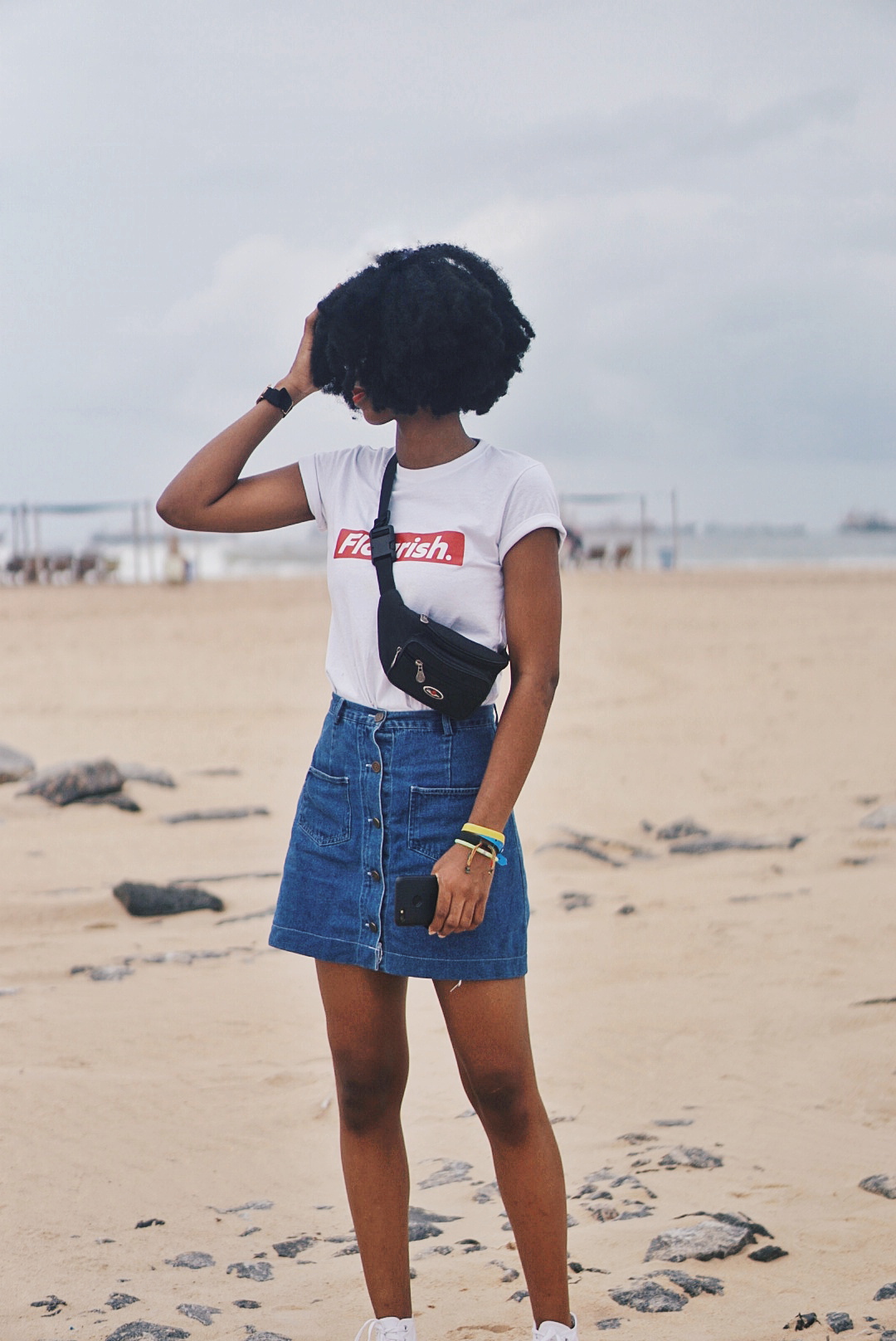 Nigerian blogger Cassie Daves in Cassie Daves flourish tee and a denim mini skirt and fanny pack