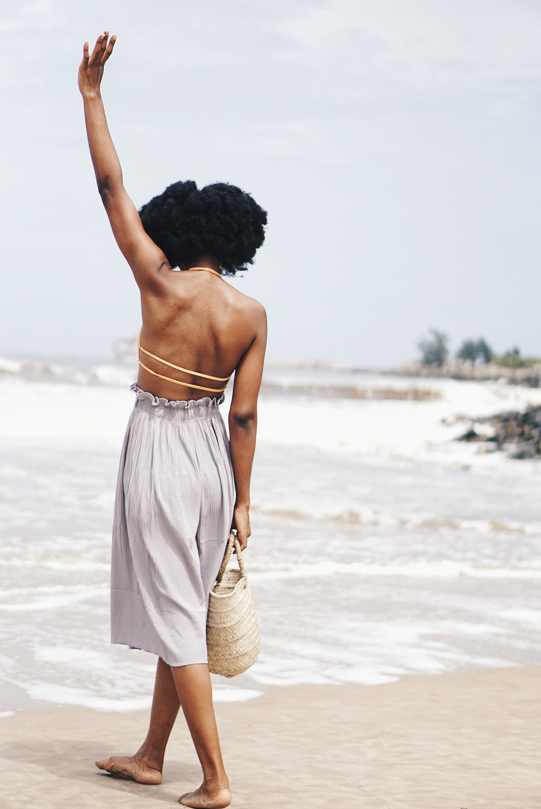 Bikini alternative to swimsuit - Nigerian Lifestyle blogger Cassie Daves with hands in the air at Tarkwa bay beach lagos