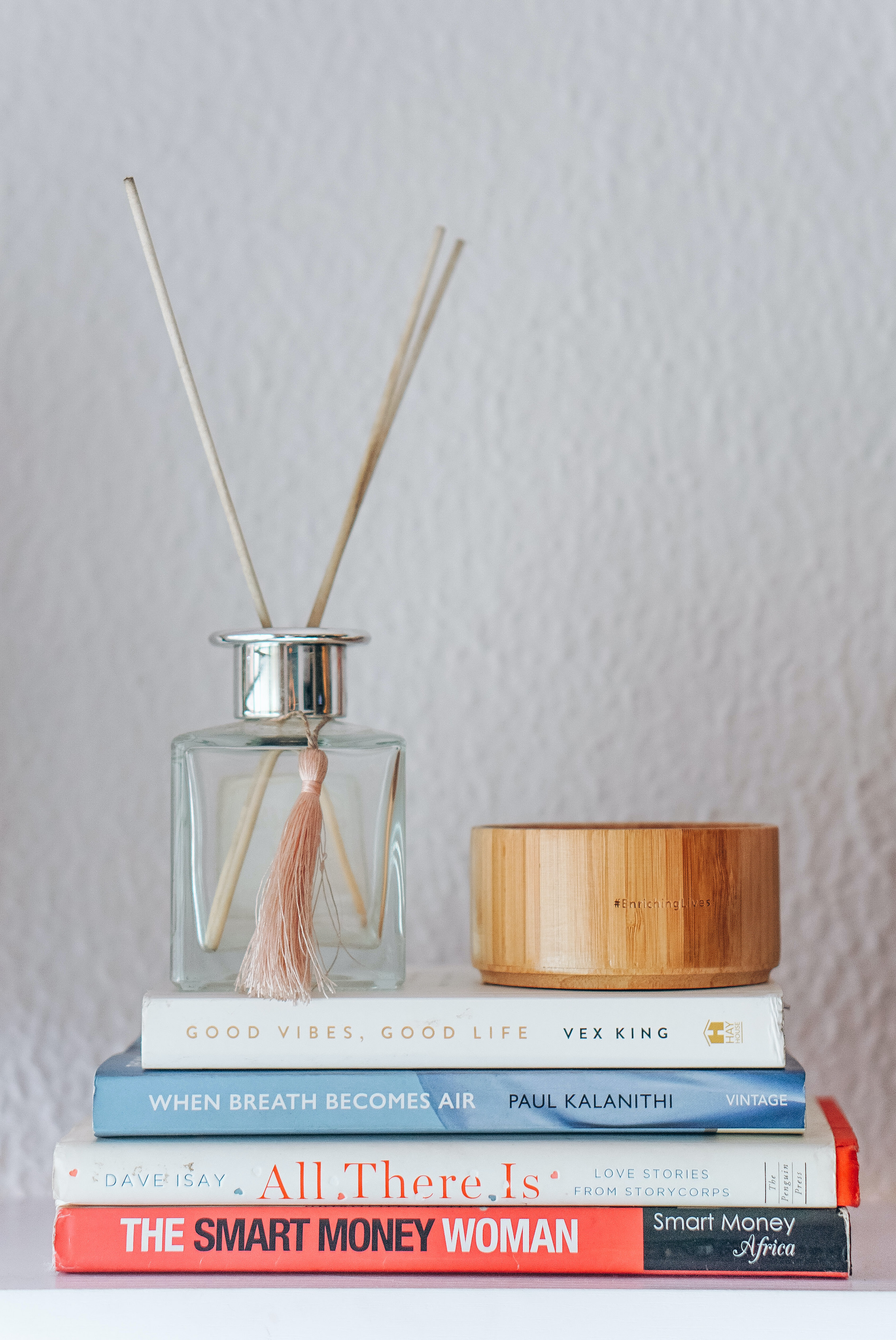 diffuser sticks and stack of books on a home office shelf
