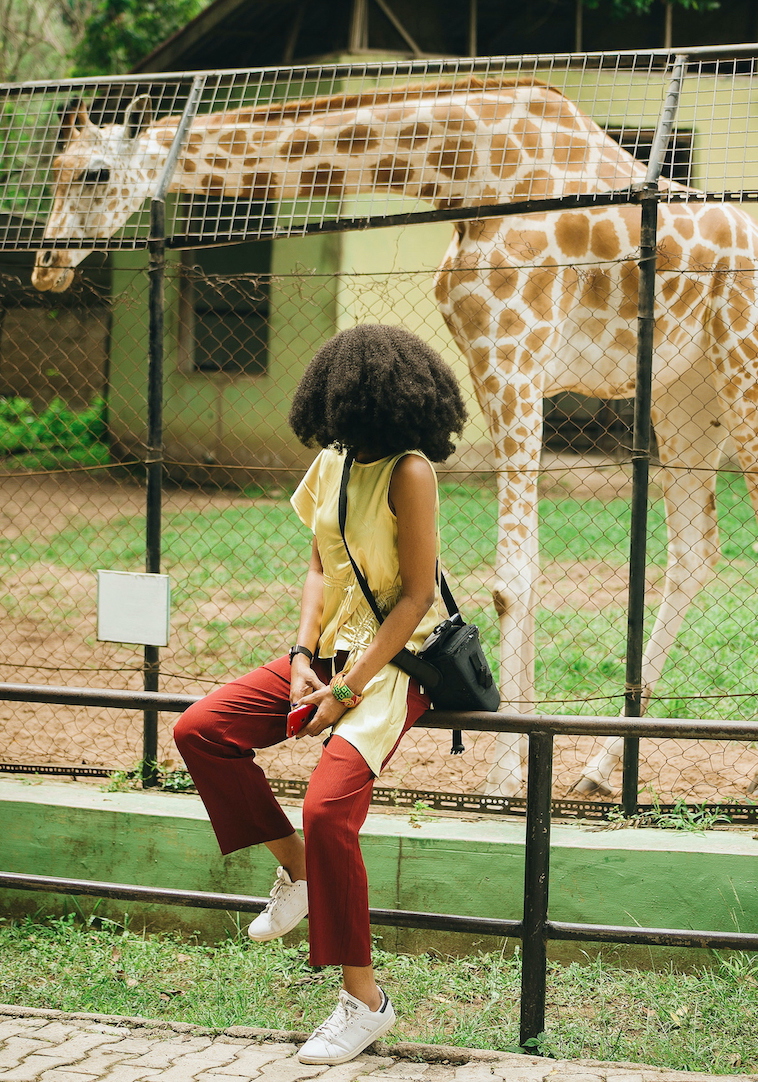 Blogger Cassie Daves at University of Ibadan zoo posing with a giraffe