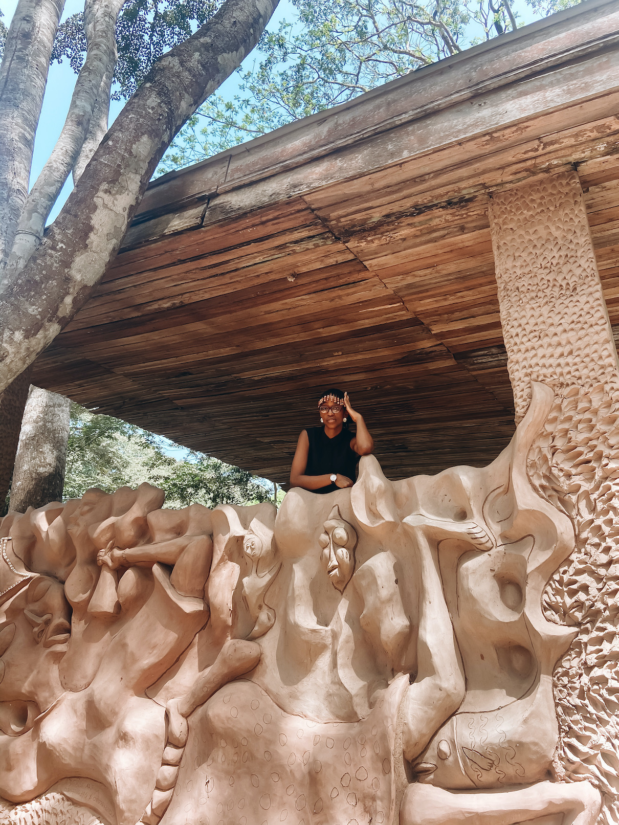 Nigerian travel blogger cassie daves standing at the entrance to the osun osogbo grove